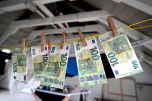 Des billets de 100 euros étendus sur une corde à linge, à Essen, en Allemagne (image d’illustration). © Photo by Malte Ossowski/SVEN SIMON / SVEN SIMON / dpa Picture-Alliance via AFP