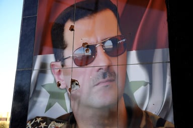 Un portrait de Bachar al-Assad criblé de balles, à Alep, en décembre. © Rami al SAYED / AFP
