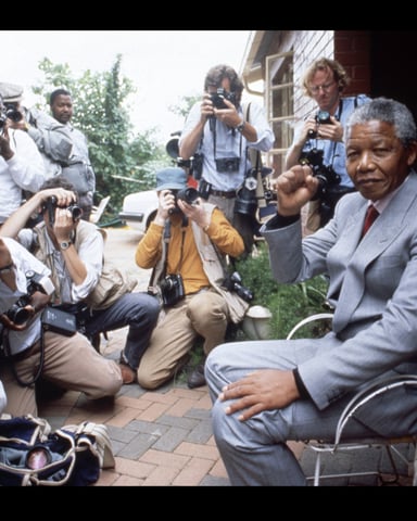 Nelson Mandela entouré de photographes dans sa maison de Soweto, le 15 février 1990, à Johannesburg. © Georges MERILLON/GAMMA-RAPHO.