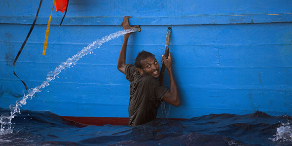 Un homme s'accroche à une embarcation secourue le 29 août au large de la Libye. &copy; Emilio Morenatti/AP/SIPA