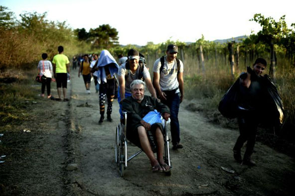 Abou Mohammed, syrien de 74 ans blessé à la colonne vertébrale, traverse les Balkans en fauteuil roulant pour rejoindre l'Europe, le 29 août 2015 près de Guevgueliya en Macédoine. &copy; Aris Messinis/AFP