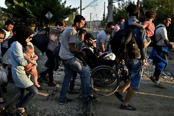 Abou Mohammed, syrien de 74 ans blessé à la colonne vertébrale, traverse les Balkans en fauteuil roulant pour rejoindre l&#039;Europe, le 29 août 2015 près de Guevgueliya en Macédoine Abou Mohammed, syrien de 74 ans blessé à la colonne vertébrale, traverse les Balkans en fauteuil roulant pour rejoindre l'Europe, le 29 août 2015 près de Guevgueliya en Macédoine. &copy; Aris Messinis/AFP