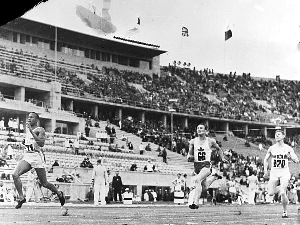 Jesse Owens sur la première place du podium le 11 août 1936 face à la foule effectuant le salut hitlérien. © Uncredited/AP/SIPA