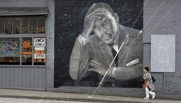 Une femme passe devant une grande peinture murale du pasteur Martin Luther King Junior sur le côté d'un restaurant, peint par l'artiste James Crespinel dans les années 1990 et restauré plus tard, le long de la route Martin Luther King Junior. À Seattle (États-Unis), le 3 avril 2018 &copy; Elaine Thompson/AP/SIPA