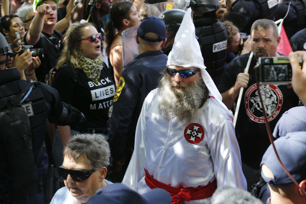 Un homme revêtant la tenue du Ku Klux Klan, à Charlottesville, aux États-Unis, le 8 juillet. Il défile devant des militants anti-racistes. &copy; Steve Helber/AP/SIPA
