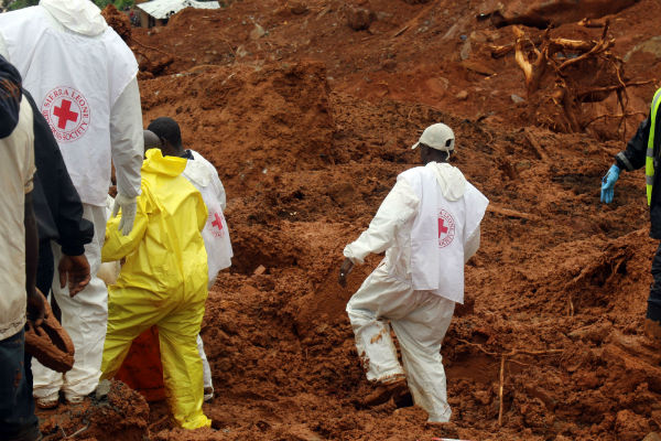 Des volontaires de la Croix Rouge en Sierra Leone recherchent des corps après une coulée de boue à Freetown, lundi 14 août 2017. &copy; AP/SIPA