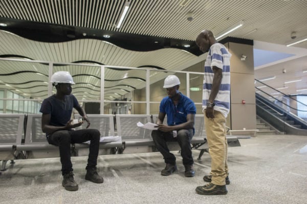 Des ouvriers travaillent sur le chantier de l'AIBD, livré le 7 décembre 2017, avec cinq ans de retard sur le calendrier initial. &copy; Sylvain Cherkaoui/Cosmos pour Jeune Afrique