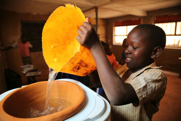 Un enfant ougandais ravis d'avoir accès à l'eau potable &copy; Spouts of Water