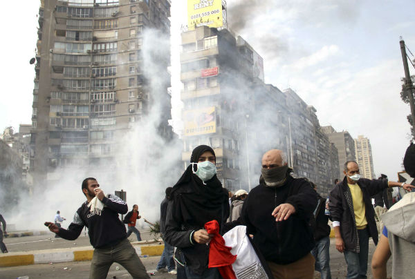 Des manifestants égyptiens fuient la police anti-émeutes qui leur tirent du gaz lacrymogène au Caire, le vendredi 28 janvier 2011 &copy; Ahmed Ali/AP/SIPA