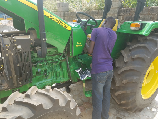 Un ingénieur de Hello Tractor en pleine réparation d'un tracteur. &copy; Hello Tractor.