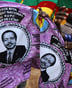 People hold a piece of cloth with pictures of Cameroon’s President Paul Biya, near a street stall at the Carrefour Wada district in the capital Yaounde October 7, 2011. Biya, on course to win Sunday’s election, will use a new term to try to build a favourable legacy to his decades in power with major construction projects, and to anoint a successor, analysts say. REUTERS/Akintunde Akinleye (CAMEROON – Tags: POLITICS ELECTIONS) © REUTERS/Akintunde Akinleye